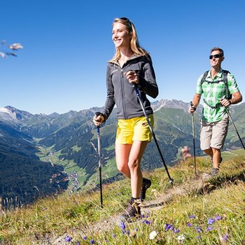 Paar beim Wandern in den Alpen mit traumhaftem Panoramablick nahe Hotel Kristall.