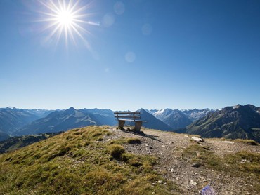 Sonniger Aussichtspunkt mit Bank und Panoramablick auf die Zillertaler Alpen.