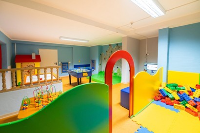 Heller Indoor-Spielbereich mit Bausteinen, Kletterwand, Tischfußball und Spielecke für Kinder im Hotel in Finkenberg.